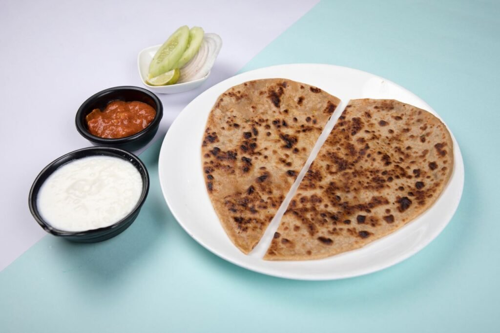 Close-up of Indian paratha served with chutneys and salad. Perfect for food photography.